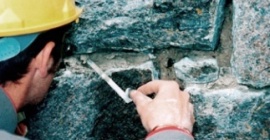 Craftsman pointing stonework with lime mortar