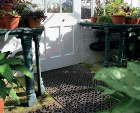 Glasshouse interior with cast iron staging for potted plants and patterned floor grating