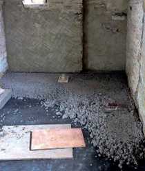 Dark grey geotextile layer partially buried beneath the incomplete limecrete layer