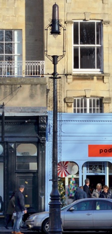 Slender, elegant arc street light with shopfronts behind