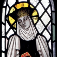St Ermengild depicted with golden halo and surrounded by largely undecorated clear glass quarries