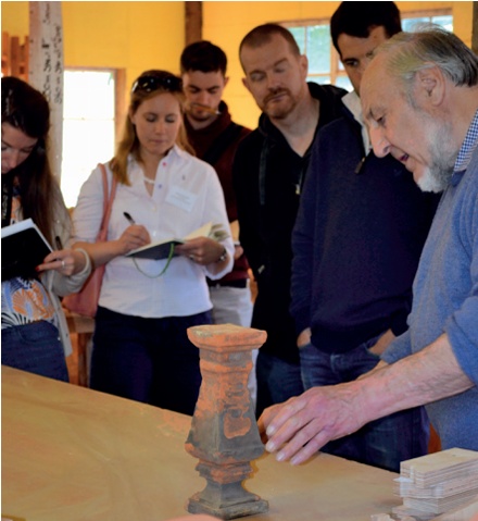 Delegates make notes while an expert discusses a terracotta baluster