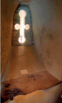 Anchorite window with view of altar and worn timber cill in foreground