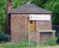 Restored  brick-built bath house with slated toof and small chimney