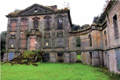 Derelict villa with boarded up windows and plant growth sprouting from its masonry