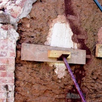A stitching repair is supported by a board held in place with a steel prop