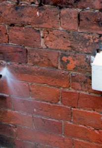 Trial area of brickwork being rinsed with a low-pressure water jet