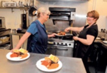 Hot food being plated up in a well-equipped church kitchen