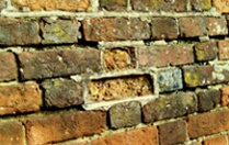 Badly eroded area of historic brickwork framed by the cement pointing 'repair' that caused it