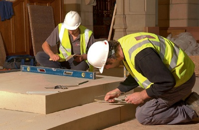 Stonemasons pointing a stone plinth