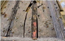 Close-up of timber door with two small areas of red paint