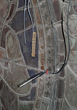 Monitoring equipment fixed to stained glass window