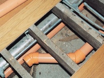 Plastic sprinkler pipe running under floor joists