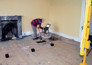 Sensors connected to a lap-top are arranged at intervals on a timber floor