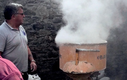 Clouds of steam billow from a large tub during lime slaking