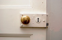 Detail of timber panelled door with brass doorknob