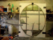 Oval section of crown glass glazing awaiting repair in the workshop