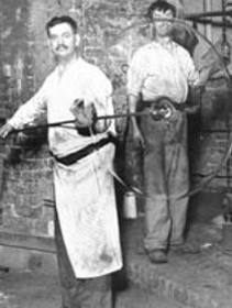 b/w photo showing a glassmaker holding up a glass 'crown'