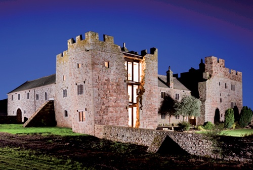 Night-time shot of Blencow: a new glazed wall spans the dramatic three-storey breach in the east wall