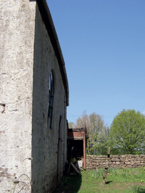 Bowed external wall with distinct curvature visible along the line of the eaves