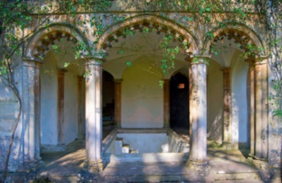 The arcaded ground floor of the Corsham Court bath house with empty plunge pool visible through central arch