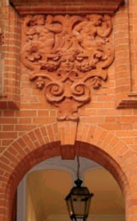 Rubbed brick arches and reliefs featuring fine floral decoration, nude figures and female face
