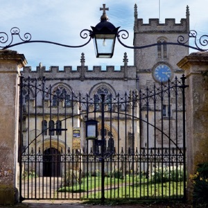 Closed wrought iron gates with historic church in background