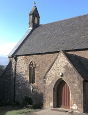 Chapel roof with lead-capped stone parapet from bellcote to eaves height