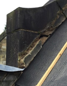 Heavily eroded masonry at junction of lead flashing and gable parapet