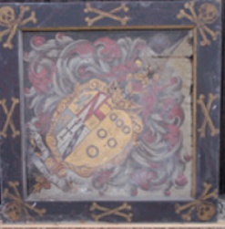 Kirklington hatchment before restoration in painted wood frame decorated with skull and crossed bones motifs