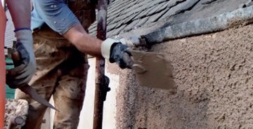 Hand-cast harling is thrown onto the wall using a flat, square trowel