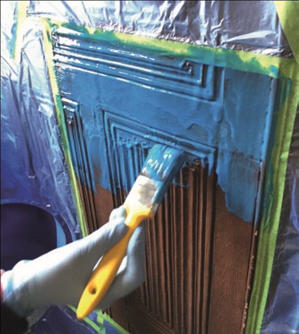 Moulding material being pasted on to an original panel with a paintbrush
