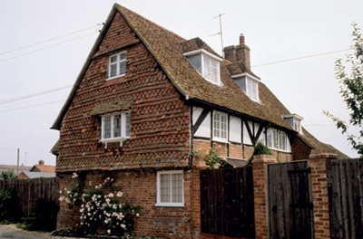 Gable end of a listed property with courses of clay tile hanging arranged in a repeating pattern