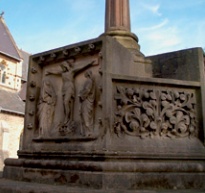 Sandstone memorial depicting Christ on the cross and alaborate floral decoration