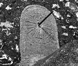 B/w photograph of mass dial with lines radiating in semi-circular formation and engraved with the name Eadric and a small bottonee cross