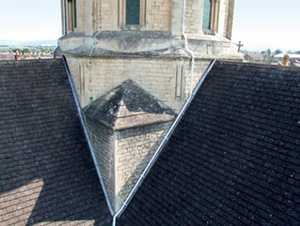 Church tower and abutting roof sliopes viewed from a cherry picker platform