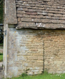 Stone-slated roof and parapet over a masonry wall