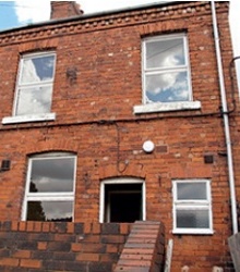 Red-brick terraced house with unsympathetic uPVC windows
