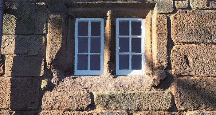 Shows the exposed masonary of a sandstone house in Wirksworth