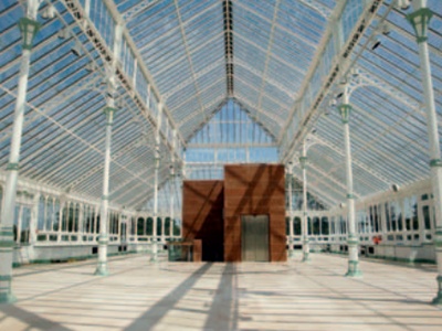The empty interior of the restored conservatory with lift housing and top of staircase at centre