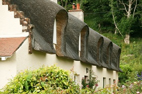 A group of cottages that have been thatched in an English traditional manner
