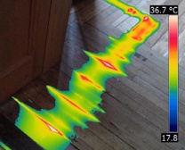 Combined thermal image and digital photograph with path of heating pipe identified by heat signatures of varying intensities