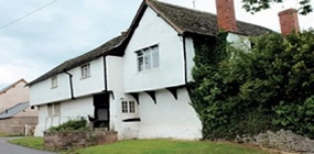 Historical timber building with different renders from the 19th and 20th century visible
