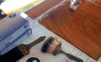Graining brushes beside a timber panel with a grained finish