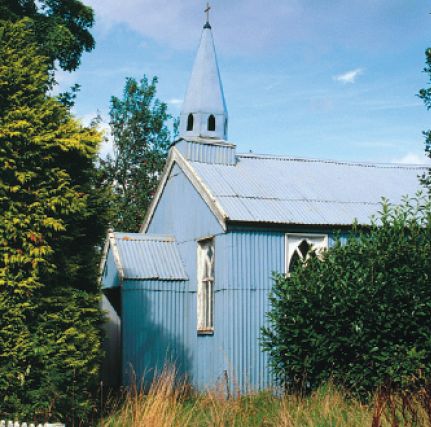 Blue corrugated iron church with spire similar to that shown in the advert above