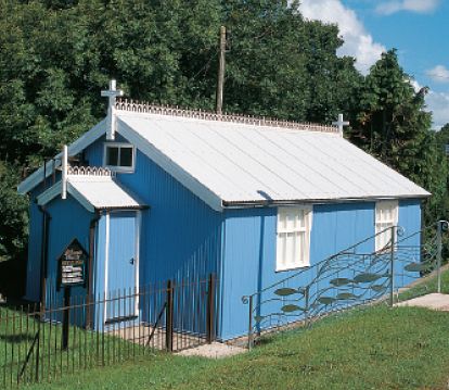 a pretty, corrugated iron church with blue walls and white roof