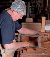 A brickmaker cleans the inner faces of the wooden brick mould 