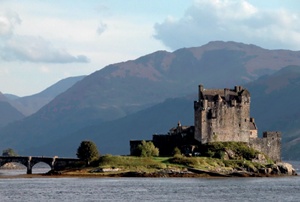 Mountains loom behind Eilean Donan Castle, built on an island in Loch Duich