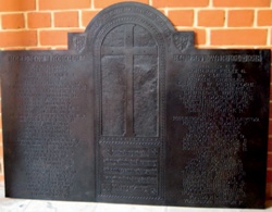 Restored bronze roll of honour plaque with large crucifix at centre