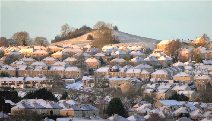 A photograph of a cluster of snow-topped houses
